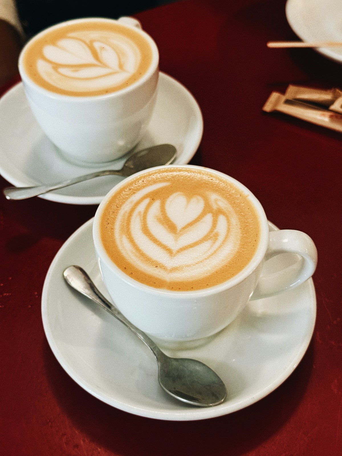 Two cups of coffee with latte art on a table
