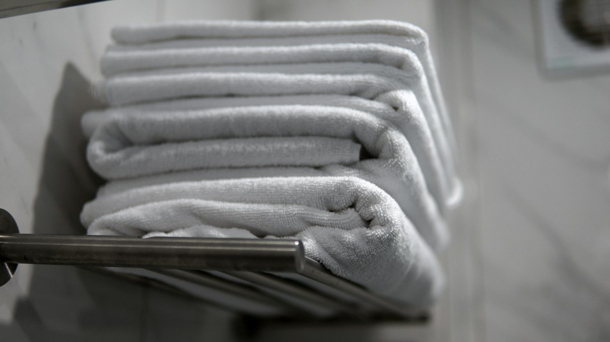 A stack of folded towels sitting on a towel rack