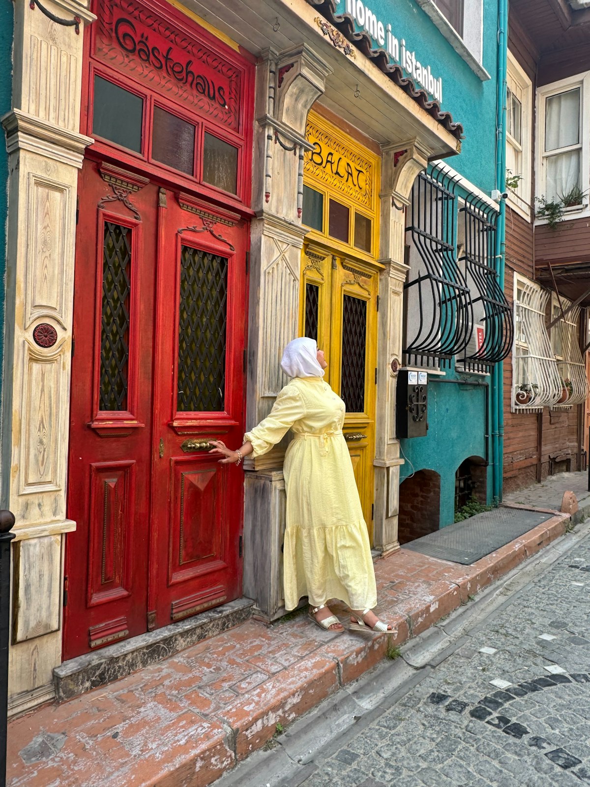 Woman poses in front of colorful doors in istanbul