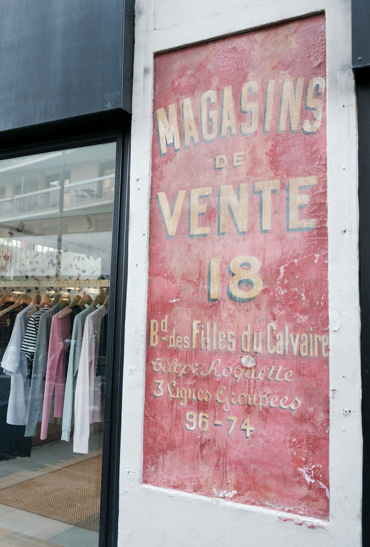 Vintage shop sign with clothing displayed in window