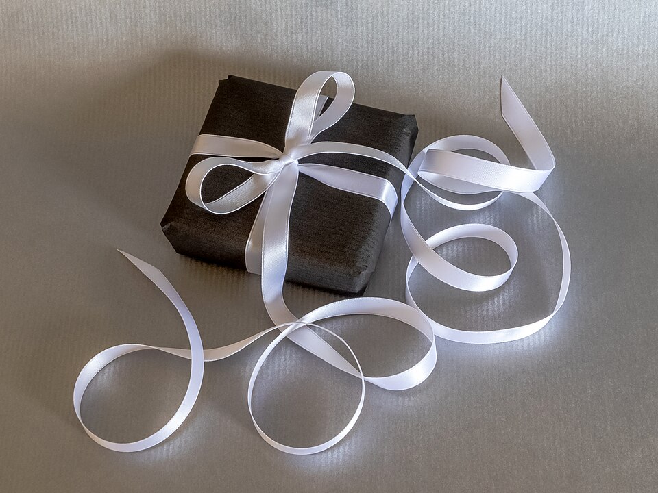 Gift wrapping with long white silk ribbon