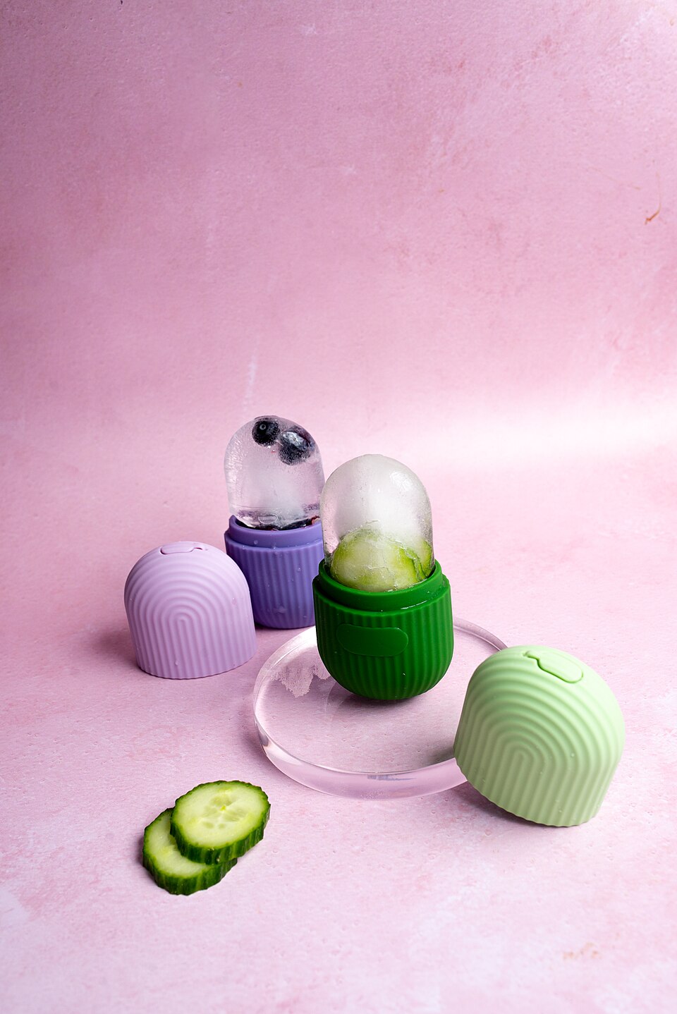 Unique silicone food storage containers in pastel colors with fresh cucumber slices on a light pink background