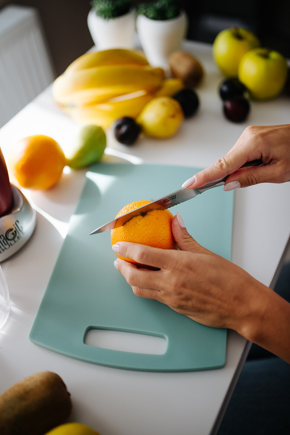 Preparing fresh fruit on a cutting board in a bright kitchen setting during the day