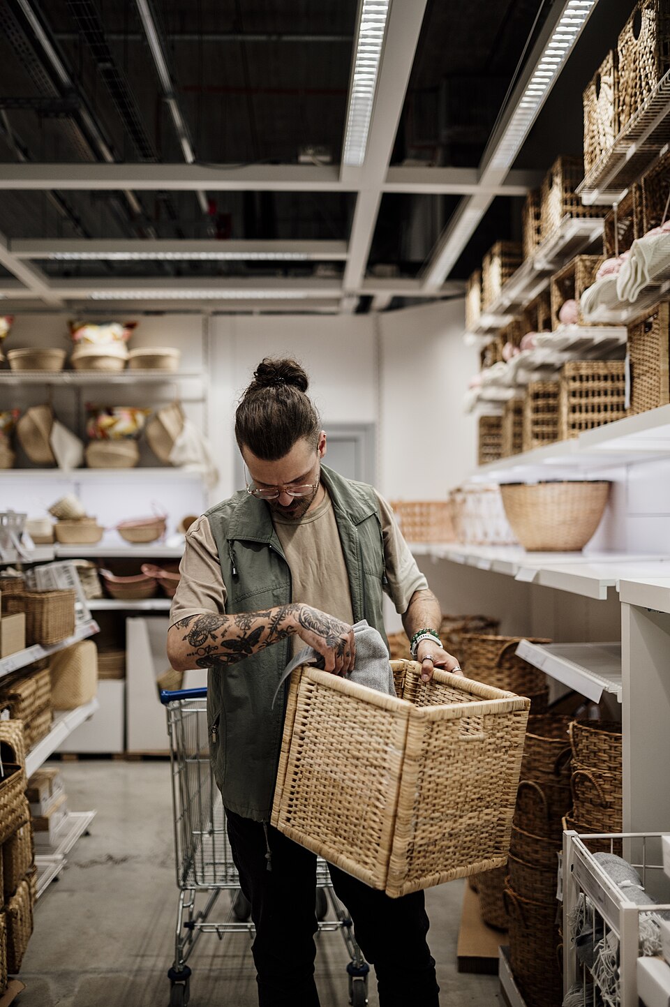Man organizing items in a shopping basket while exploring a home goods store