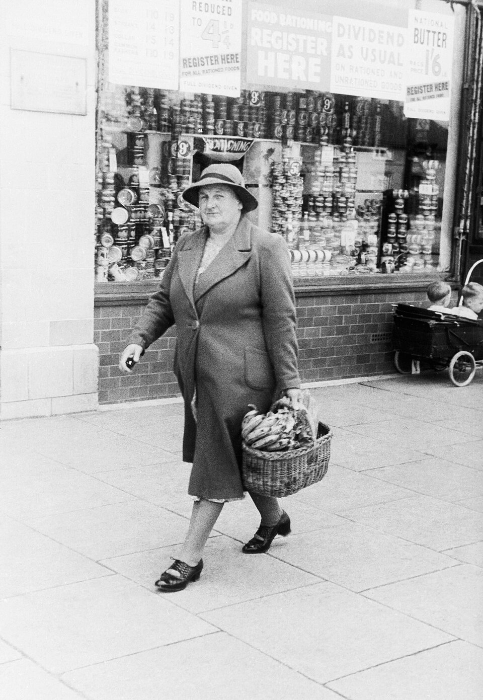 A housewife with a shopping basket full of bananas after a visit to the Co-Op store on Westhorne Avenue, Eltham in London, 1940. HU92467